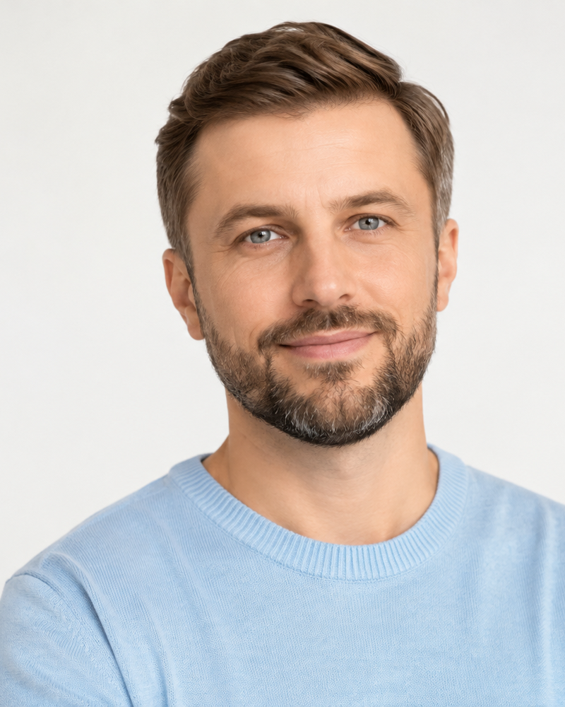 Mężczyzna z krótką brodą w jasnoniebieskim swetrze, studio, bez logo